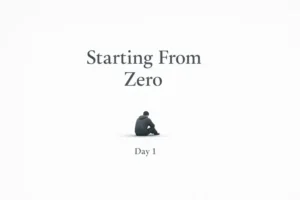 A lone man sitting quietly beneath the words ‘Starting From Zero – Day 1,’ symbolizing rebuilding life from scratch